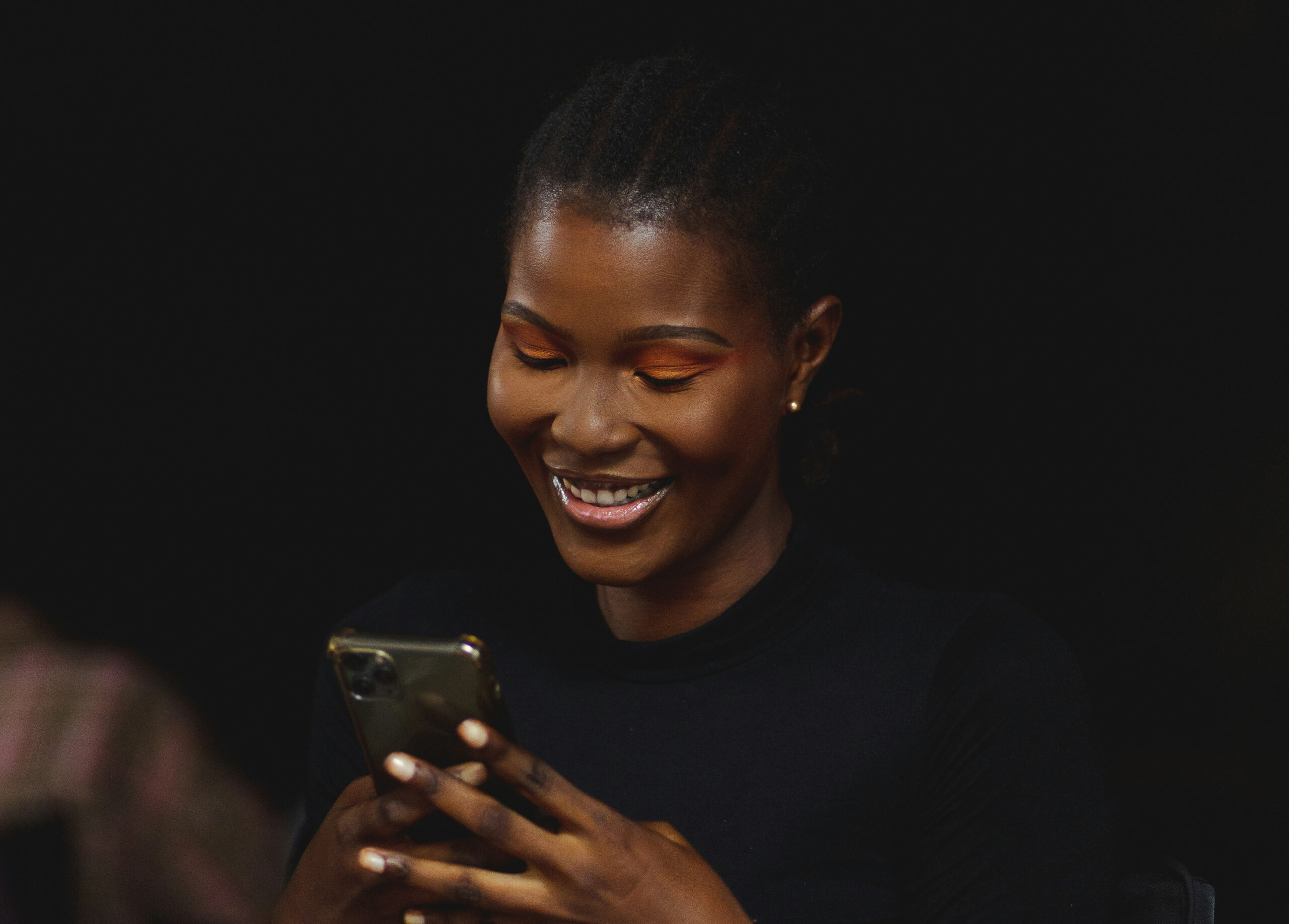 Young woman smiling while texting on her phone, illustrating themes of flirting, late-night messages, and digital connection