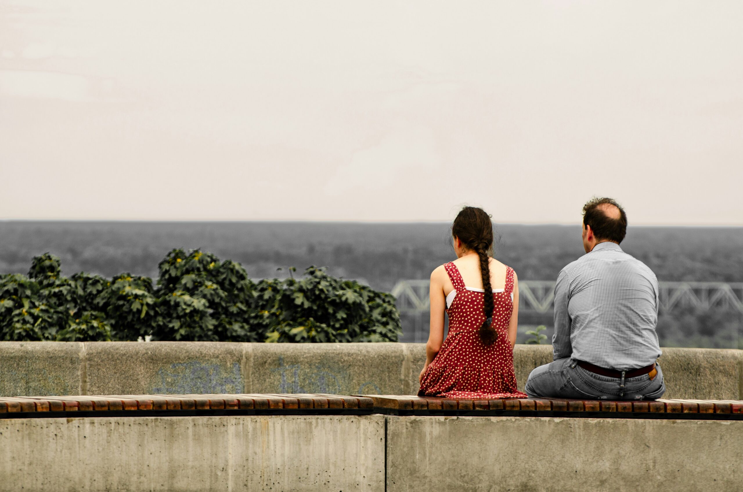 Couple sitting apart on a couch looking distant, representing the signs you may need couples therapy in Melbourne